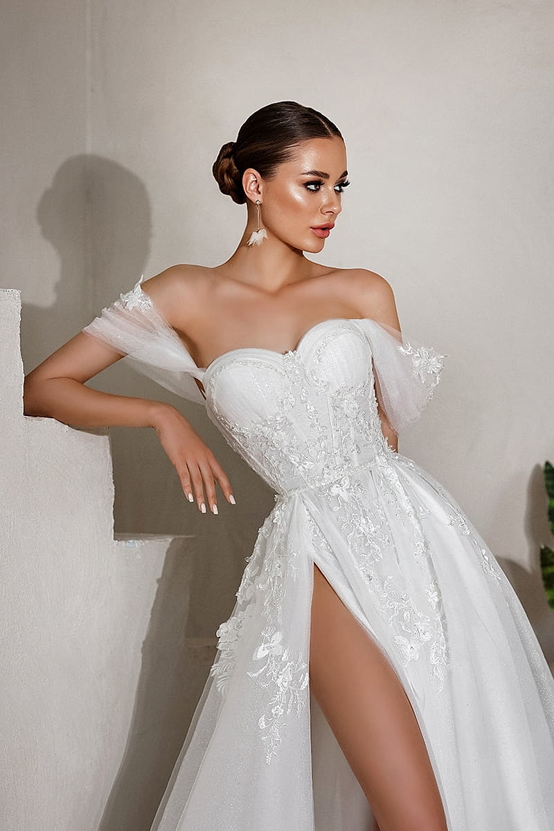 Elegant woman in a bridal gown, posing gracefully.