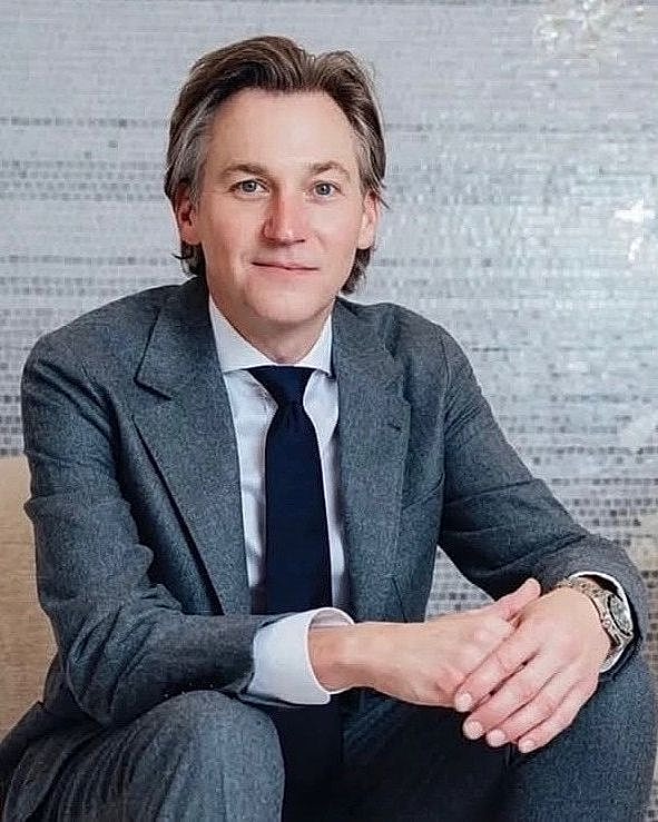Man in a suit sitting against mosaic background